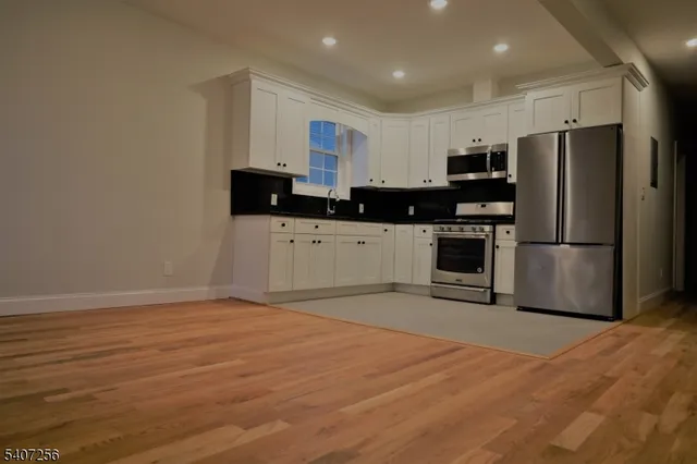 a kitchen with stainless steel appliances a refrigerator sink and microwave