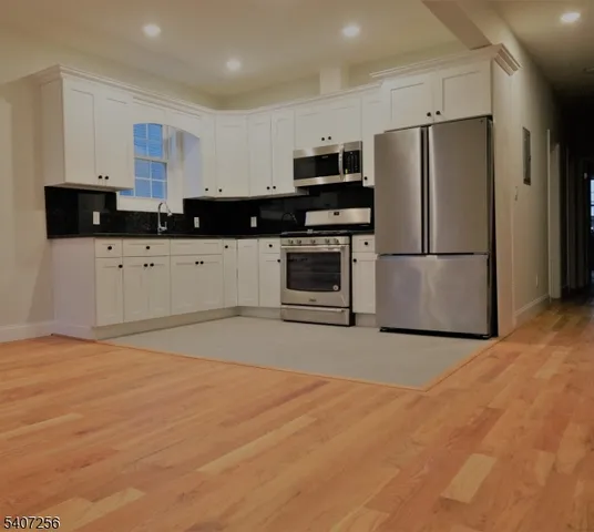 a kitchen with stainless steel appliances a refrigerator sink and microwave