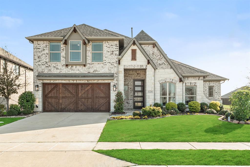 a front view of a house with a garden and plants