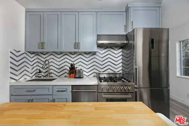 a kitchen with stainless steel appliances granite countertop a refrigerator and a stove