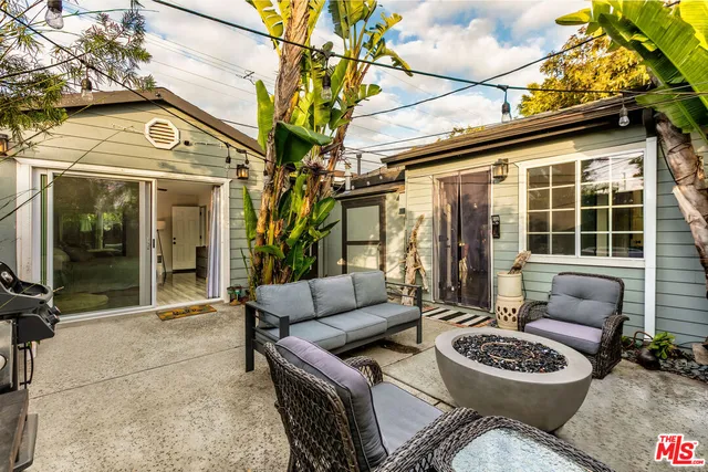 a view of a patio with couches table and chairs and potted plants