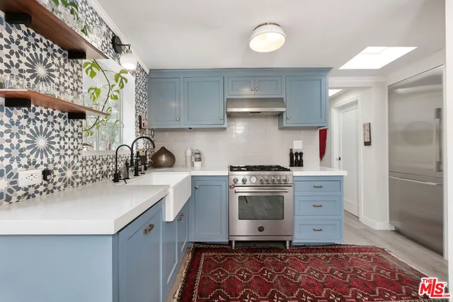 a kitchen with granite countertop a sink stainless steel appliances and cabinets