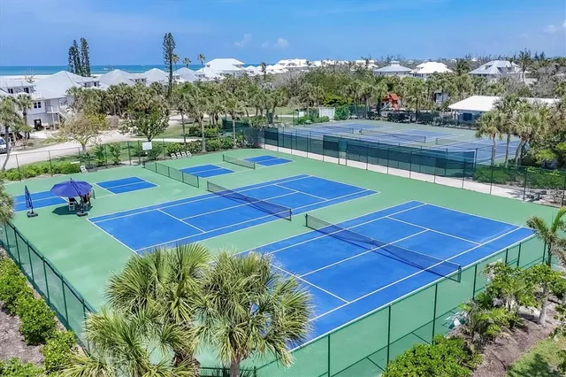 a view of a tennis ground with large trees