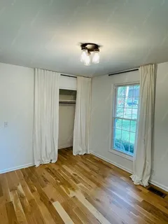 a view of a livingroom with wooden floor and window