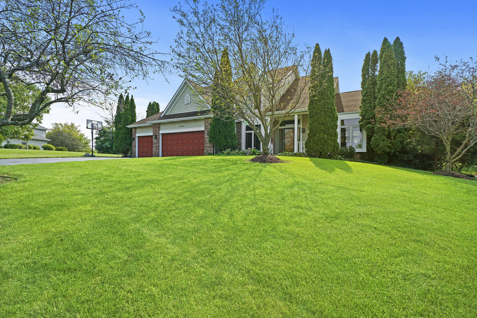 10808 Michigan Drive Spring Grove, IL 60081 - Photo 2 of 26 a view of a house with a yard and large trees