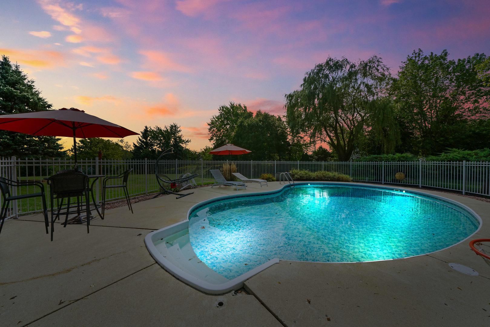 10808 Michigan Drive Spring Grove, IL 60081 - Photo 25 of 26 a view of a swimming pool with a table and chairs under an umbrella