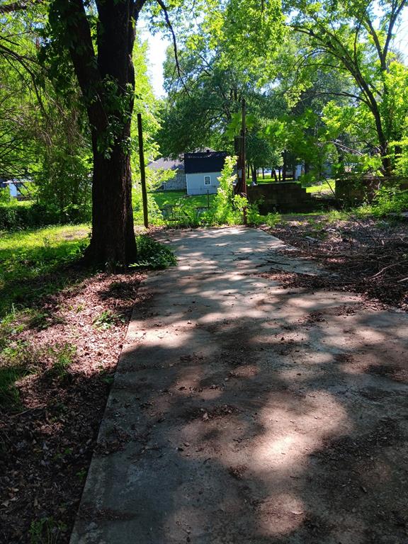 210 Spring Valley Street Gun Barrel City, TX 75156 - Photo 1 of 7 Concrete surface with surrounding mature trees and verdant foliage
