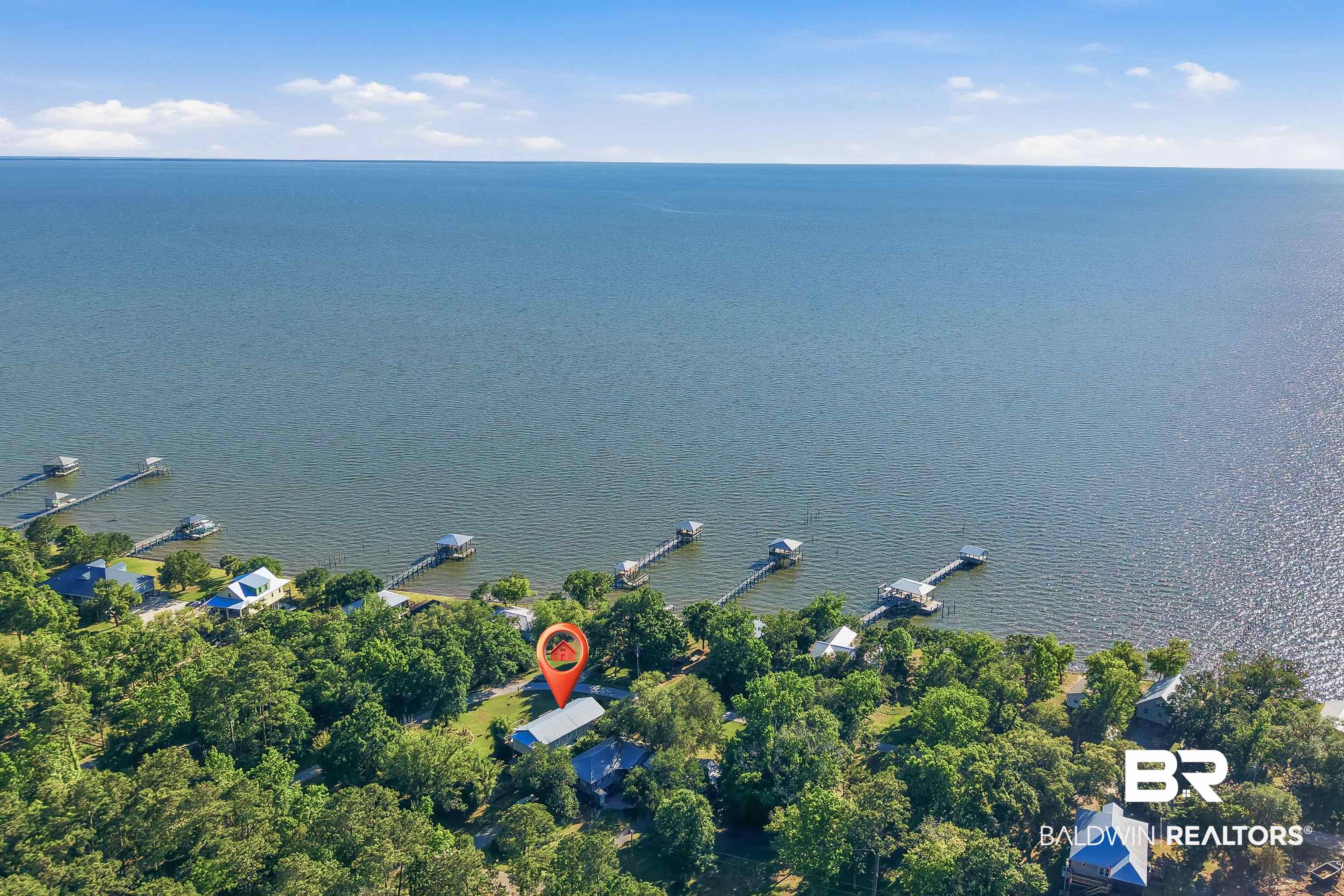 9624 North Bay Street Foley, AL 36535 - Photo 55 of 59 Waterfront property featuring extensive tree coverage, a private pier, and direct access to a large body of water