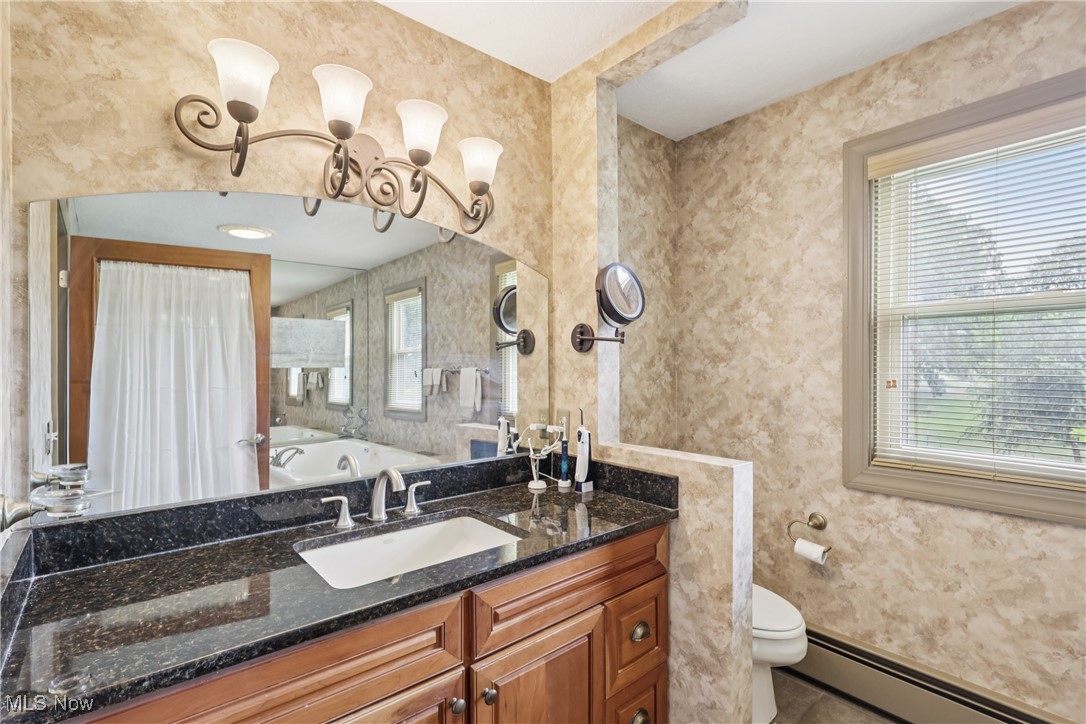 4101 Huffman Road Medina, OH 44256 - Photo 23 of 48 Full bathroom featuring a baseboard heating unit, wallpapered walls, vanity, a tub to relax in, and tile patterned flooring