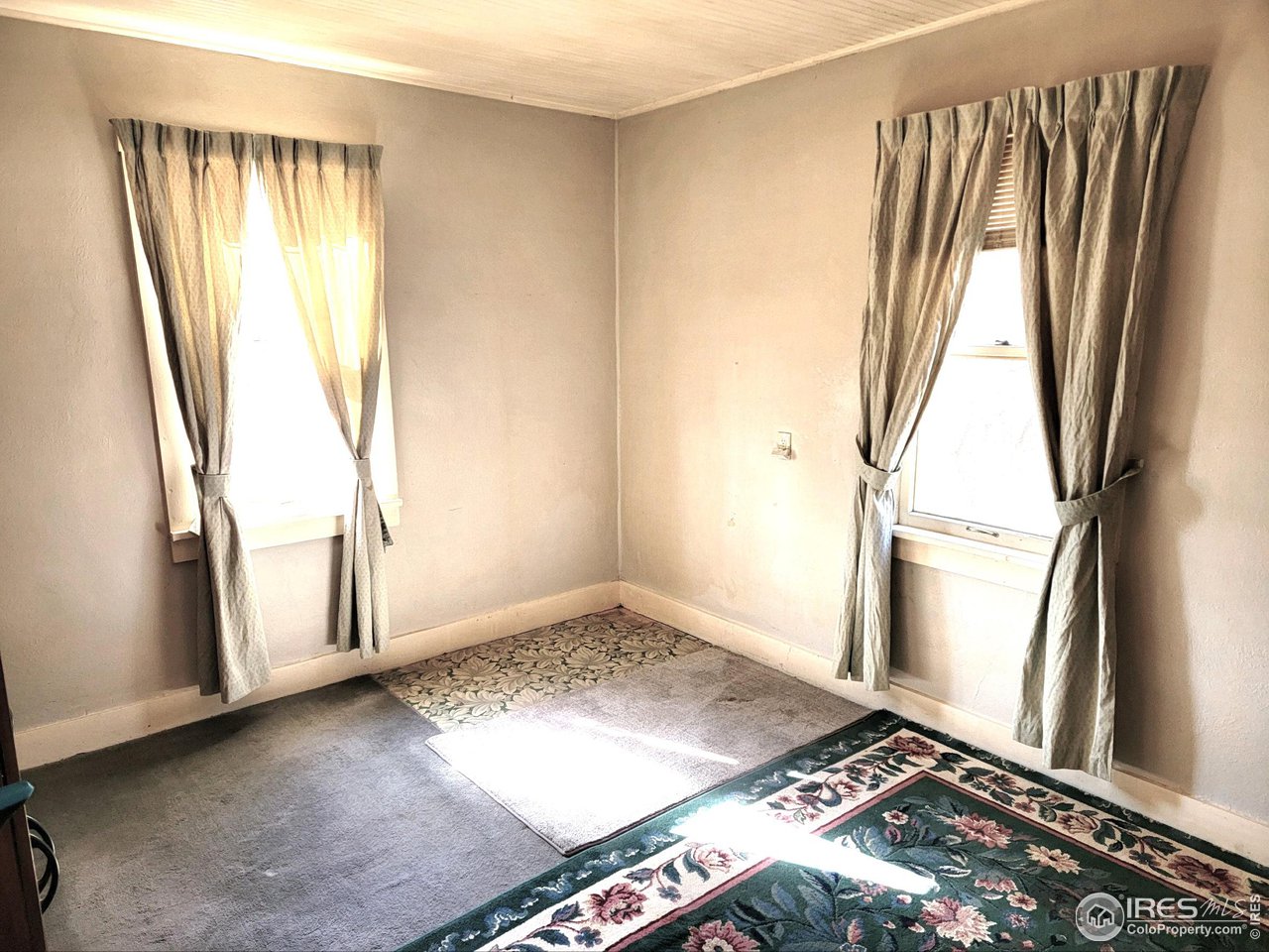528 Phelps Street Sterling, CO 80751 - Photo 8 of 12 a view of an empty room with wooden floor and a window