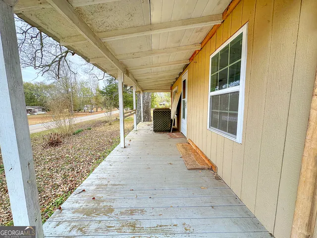 a view of porch with wooden floor and floor to ceiling window