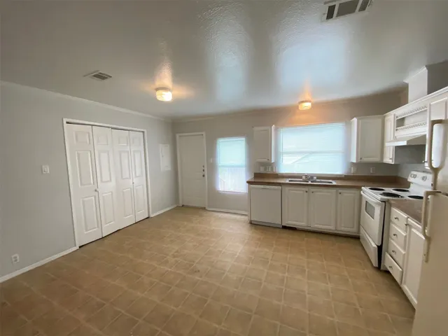 a large kitchen with a stove a sink dishwasher and a refrigerator