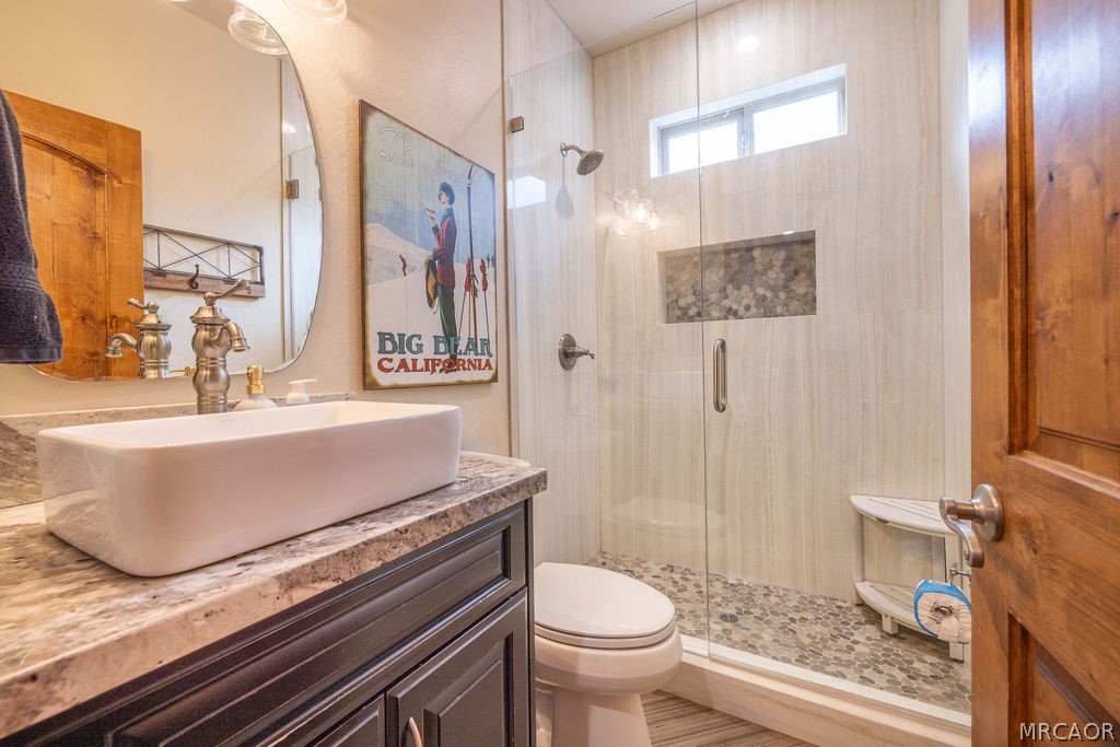 1629 Angels Camp Road Big Bear City, CA 92314 - Photo 23 of 40 a bathroom with a granite countertop sink a toilet and a mirror