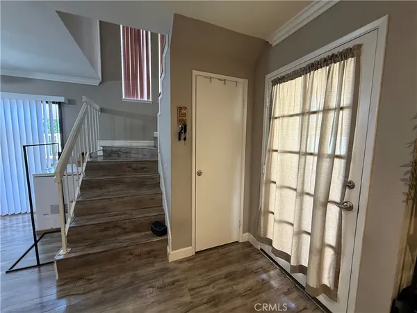 an empty room with wooden floor a ceiling fan and windows
