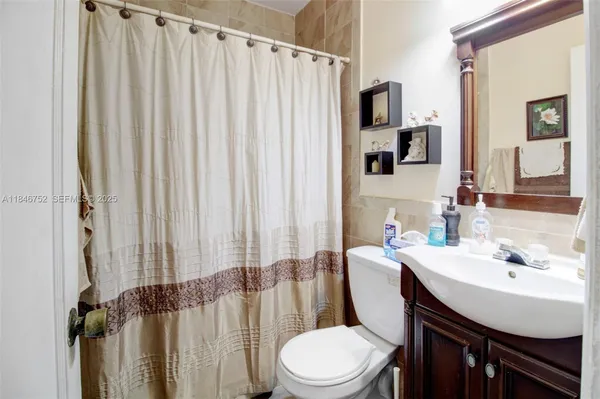 a bathroom with a sink a toilet and shower curtain