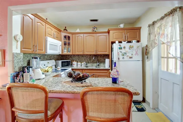 a kitchen with stainless steel appliances granite countertop a refrigerator and microwave