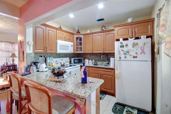 a kitchen with stainless steel appliances granite countertop a refrigerator and a stove top oven