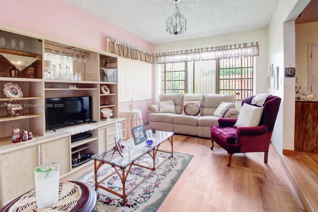 a living room with furniture a flat screen tv and a window