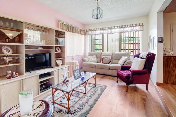 a living room with furniture a flat screen tv and a window
