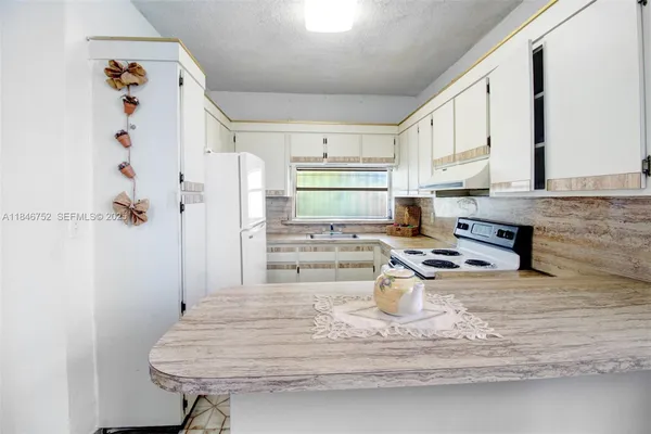 a kitchen with a refrigerator and a sink