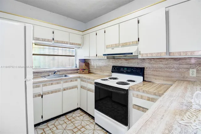 a kitchen with a stove top oven sink and cabinets