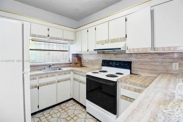 a kitchen with a stove top oven sink and cabinets