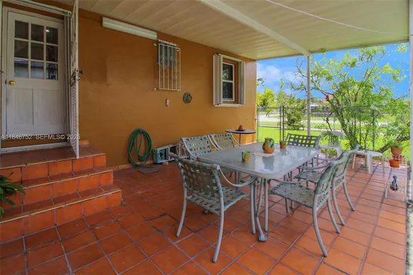 a view of a patio with table and chairs and potted plants