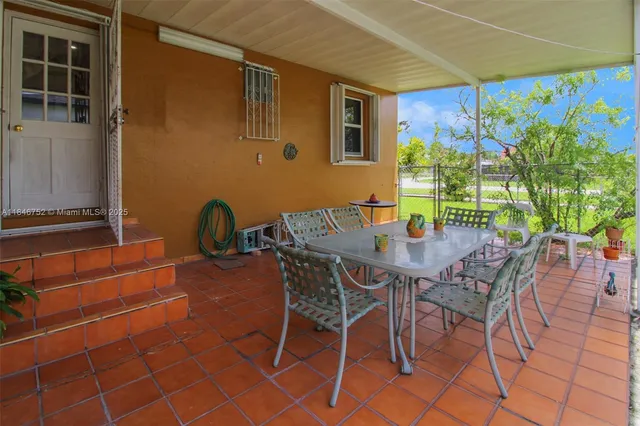 a view of a patio with table and chairs and potted plants
