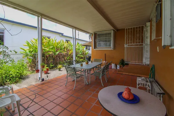 a dining room with furniture and a potted plant