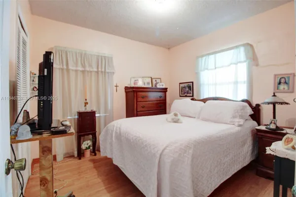 a bedroom with a bed and wooden floor