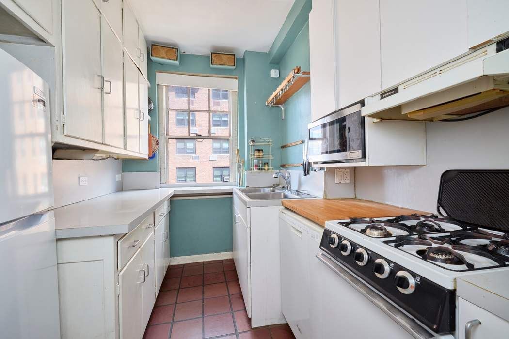 5 Riverside Drive, Unit 12C Manhattan, NY 10023 - Photo 6 of 12 a kitchen with stainless steel appliances a sink and a stove