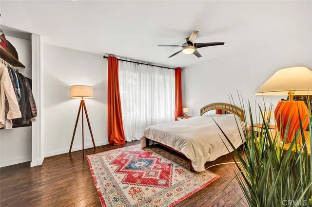 a bedroom with a bed a rug and a flat screen tv