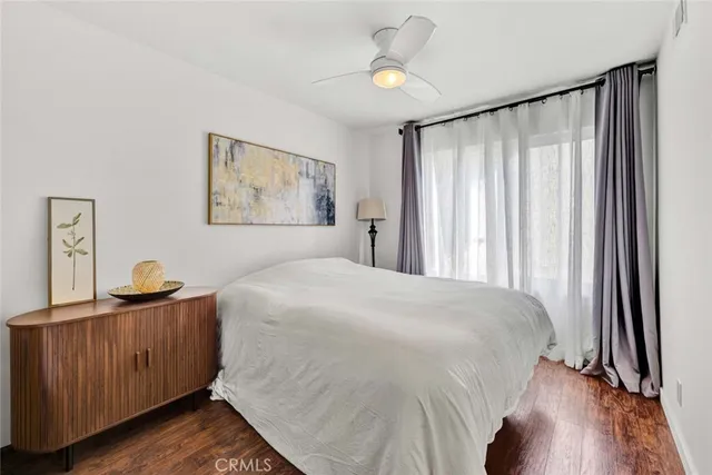 a bedroom with a bed and a dresser next to a window