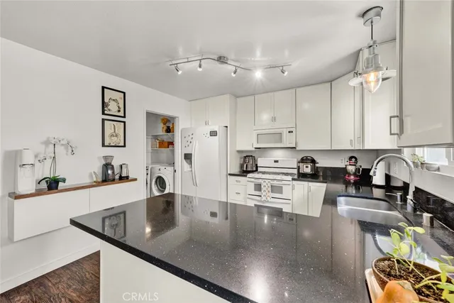 a large kitchen with stainless steel appliances granite countertop a sink a stove counter space and cabinets