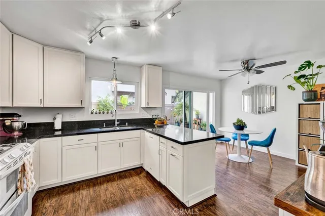 a kitchen with granite countertop a sink cabinets and wooden floor