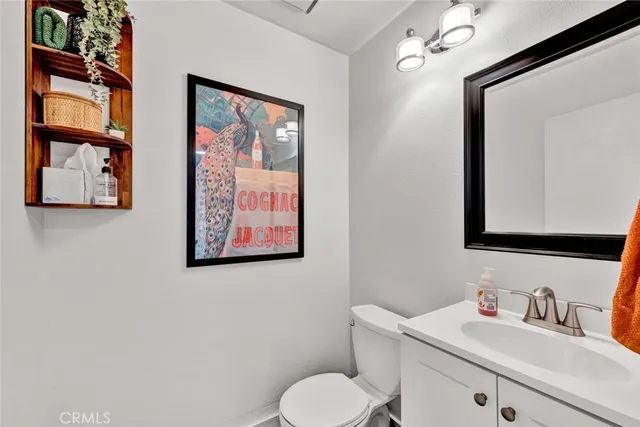 a bathroom with a toilet sink vanity and mirror