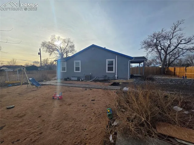 a backyard of a house with table and chairs