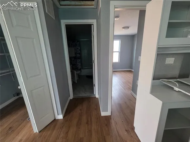 a view of a hallway with wooden floor