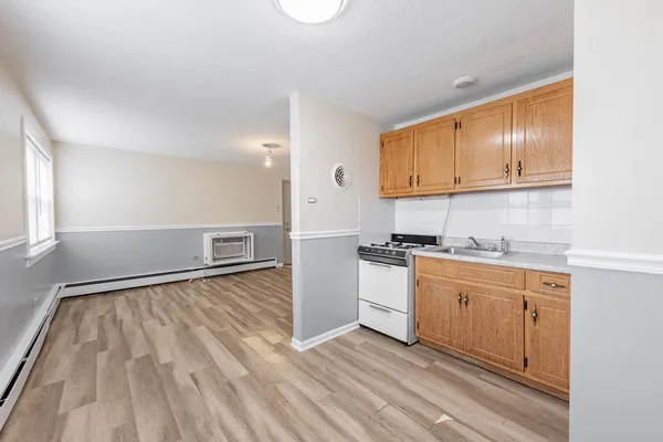 a kitchen with wooden floors and white cabinets