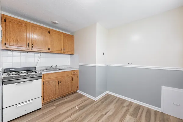 a kitchen with granite countertop cabinets stainless steel appliances and wooden floor