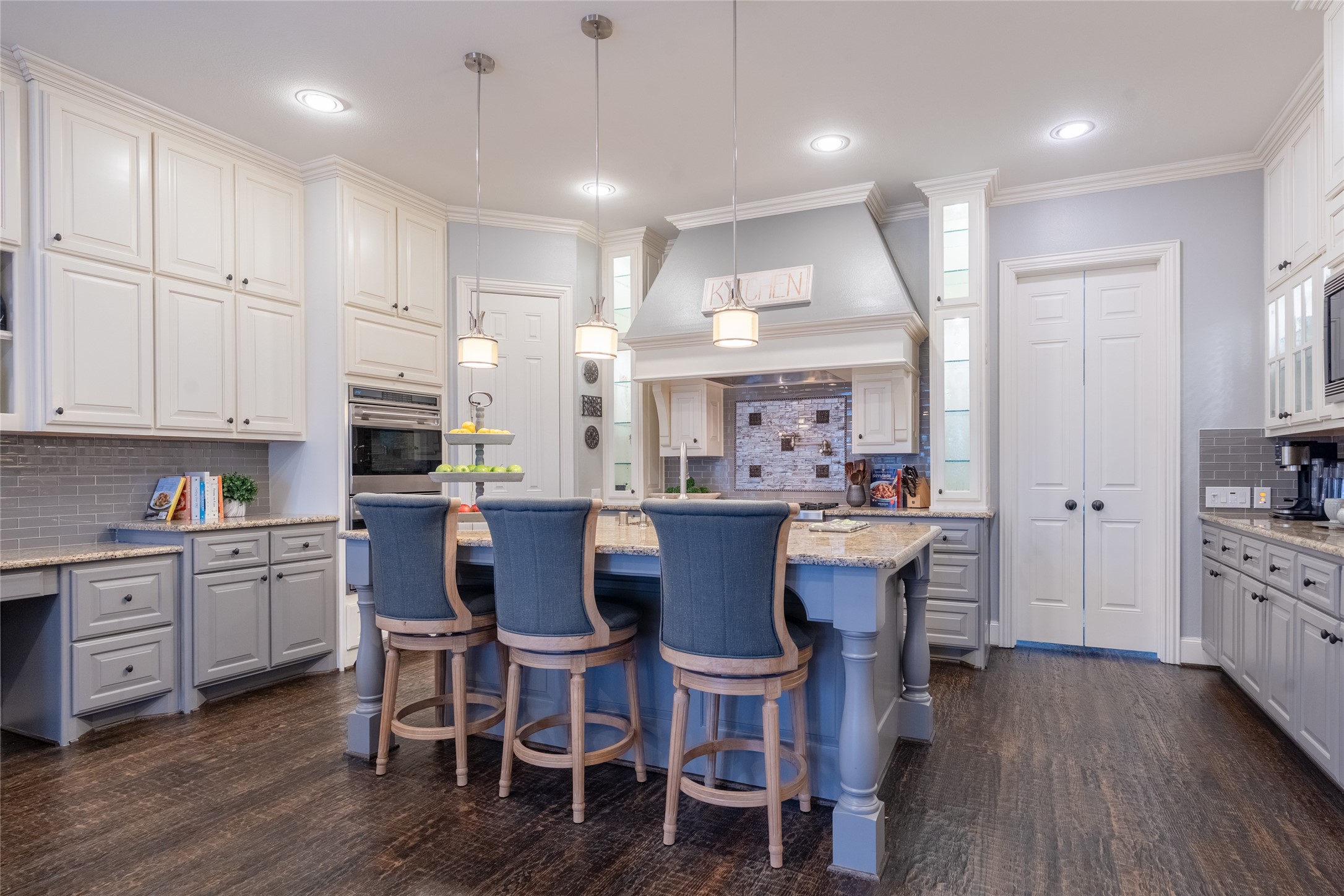 6 Rhapsody Bend Drive The Woodlands, TX 77382 - Photo 7 of 39 a kitchen with stainless steel appliances kitchen island granite countertop a wooden table chairs and white cabinets