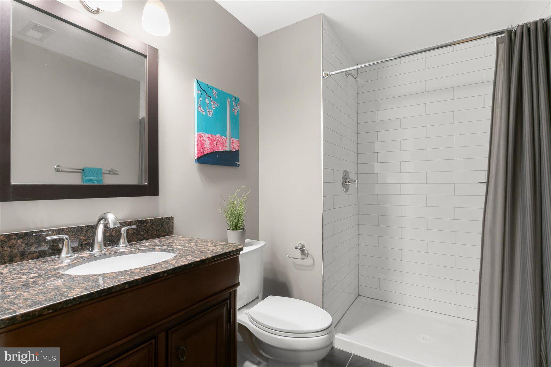 513 Gilmoure Drive Silver Spring, MD 20901 - Photo 48 of 60 a bathroom with a granite countertop sink toilet and shower