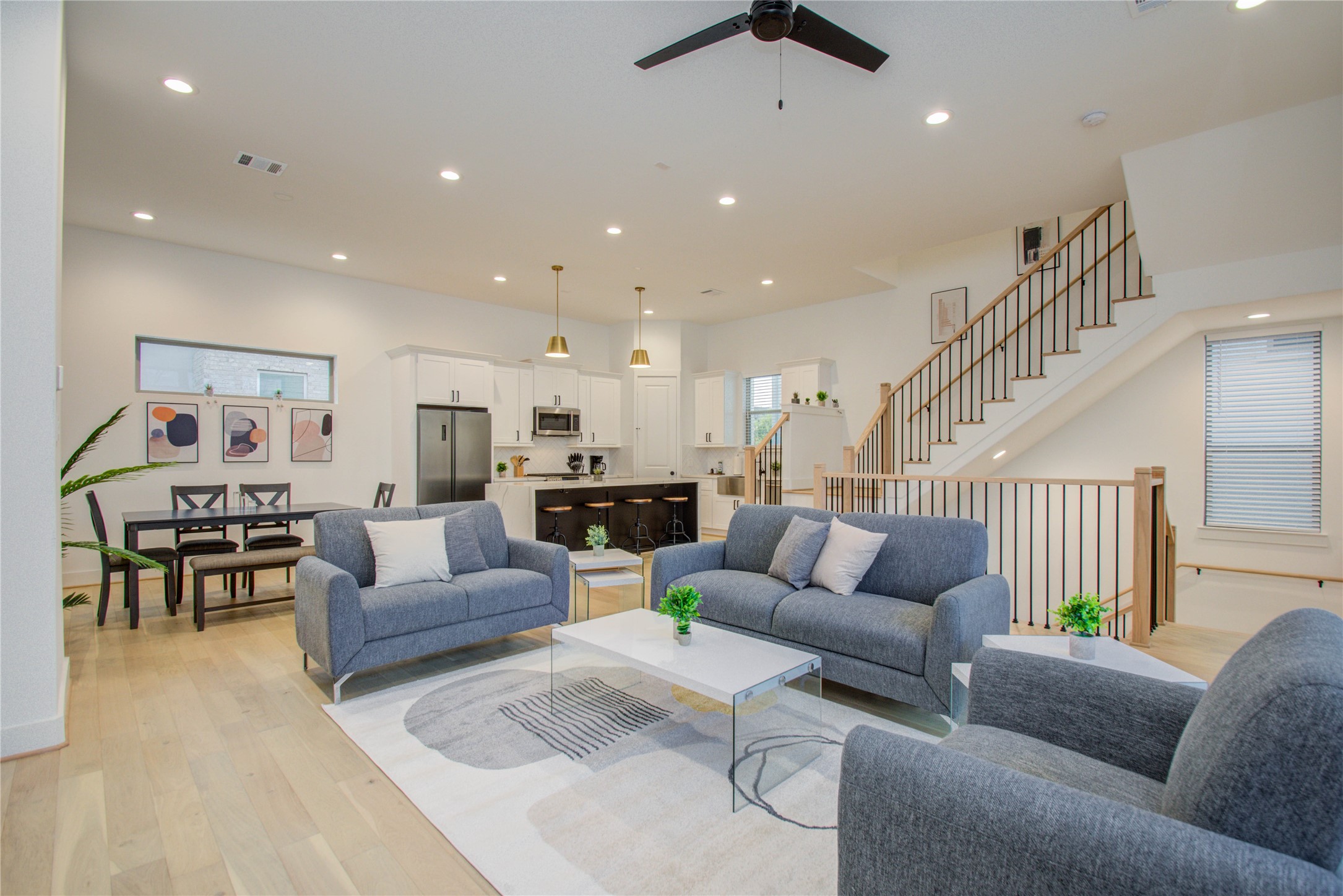 a living room with furniture kitchen view and a chandelier