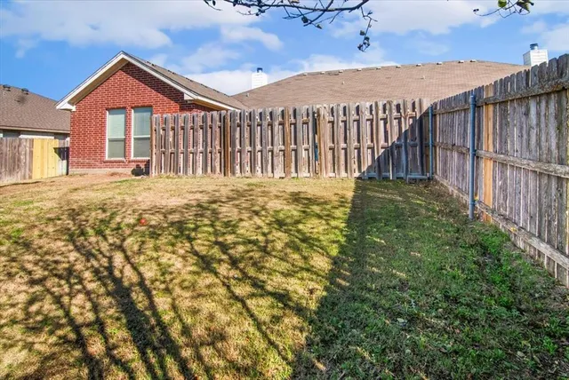 a view of a house with a large window and wooden fence