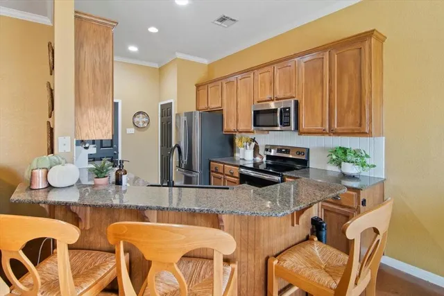 a kitchen with stainless steel appliances granite countertop a refrigerator a stove top oven a sink and dishwasher