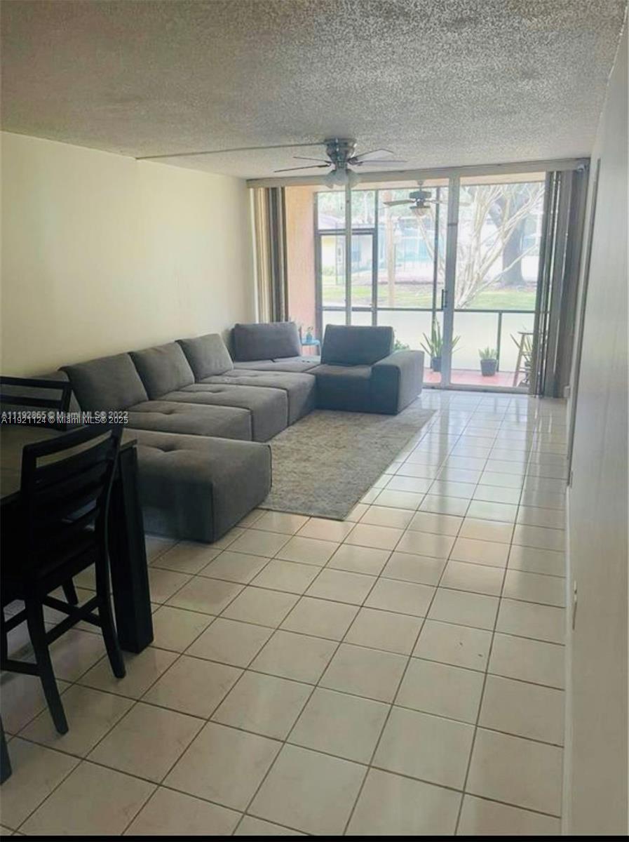 5100 Southwest 64th Avenue, Unit 101 Davie, FL 33314 - Photo 15 of 17 a living room with furniture and a floor to ceiling window