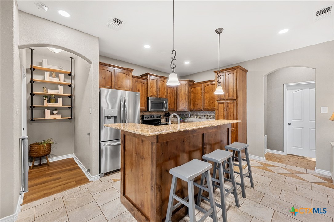 3409 Plains Street Copperas Cove, TX 76522 - Photo 7 of 33 a kitchen with a refrigerator a sink and chairs