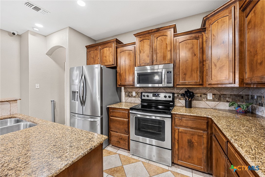 3409 Plains Street Copperas Cove, TX 76522 - Photo 8 of 33 a kitchen with stainless steel appliances granite countertop a refrigerator stove and sink