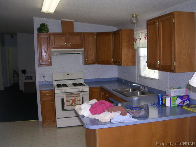 1239 Tabernacle Road Mathews, VA 23109 - Photo 22 of 22 a kitchen with stainless steel appliances granite countertop a sink stove and cabinets