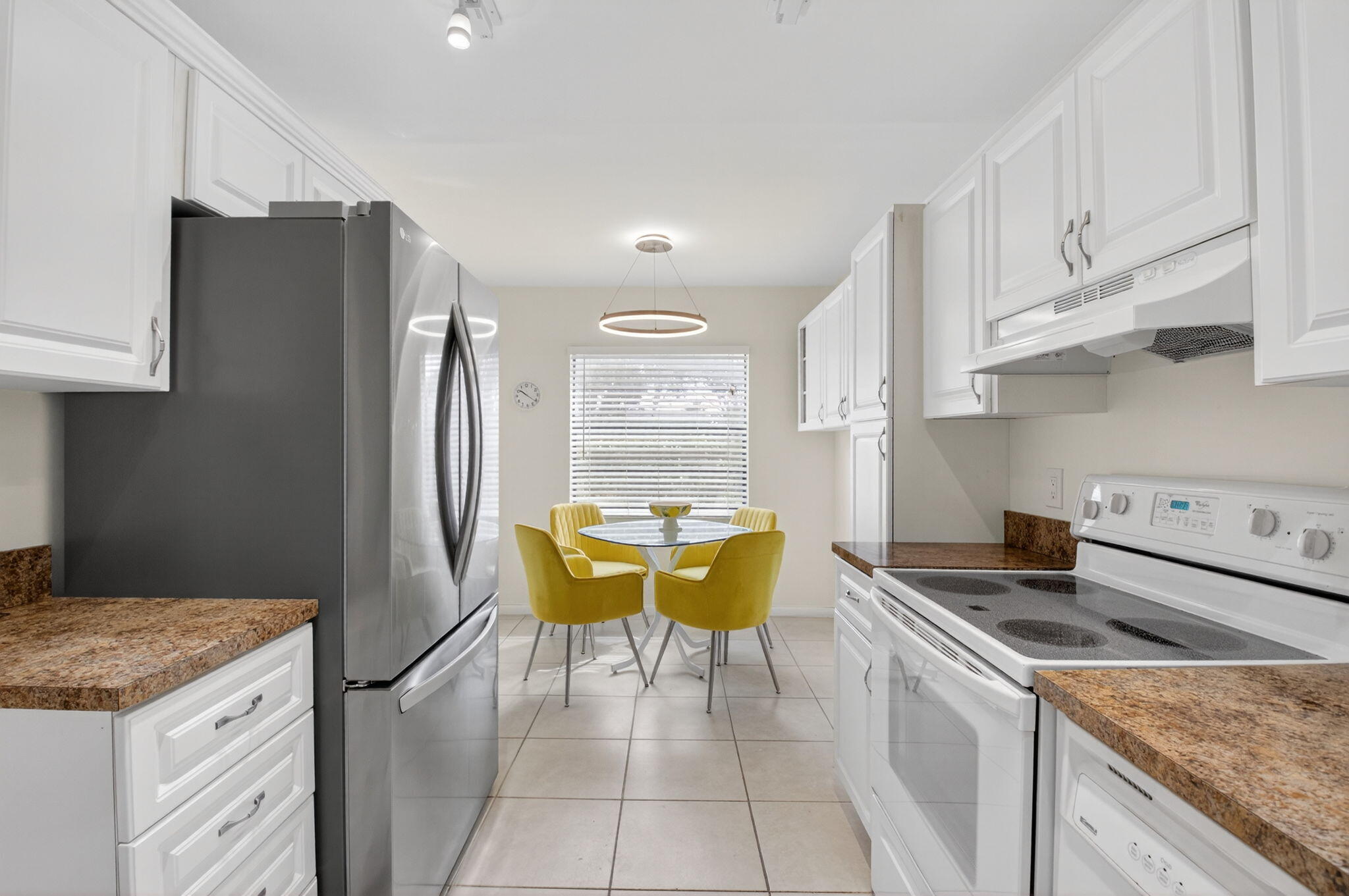 10 Southport Lane, Unit E Boynton Beach, FL 33436 - Photo 13 of 47 a kitchen with stainless steel appliances granite countertop a sink a stove a refrigerator and island